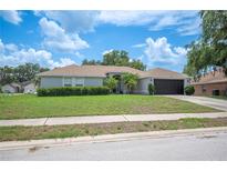 Charming single-story home with a well-maintained lawn and attached two-car garage at 6789 Ashbury Dr, Lakeland, FL 33809