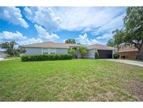 Well-maintained home featuring a manicured lawn, mature landscaping, and a neutral color palette exterior at 6789 Ashbury Dr, Lakeland, FL 33809