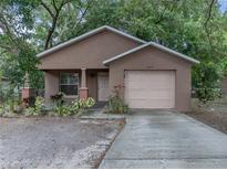 Charming single-story home with stucco exterior, attached garage, and lush landscaping at 829 N Lake Ave, Lakeland, FL 33801