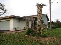 View of exterior of home, showing the stone pillars and pergola at 102 Canterbury Dr, Haines City, FL 33844