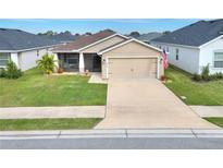 Charming single-story home featuring a two-car garage, screened-in porch, and well-manicured lawn at 1034 Corso Dr, Winter Haven, FL 33884