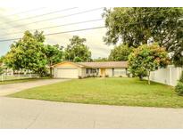 Charming single-story home with a well-manicured lawn, mature trees, and an attached one car garage at 111 Beverly Dr, Winter Haven, FL 33884