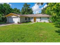 Charming single-story home featuring a brick facade, attached garage, and well-manicured front lawn at 111 Beverly Dr, Winter Haven, FL 33884