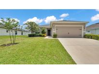 Charming single-story home with a well-maintained lawn and an attached two-car garage in a residential neighborhood at 122 St Thomas Dr, Mulberry, FL 33860
