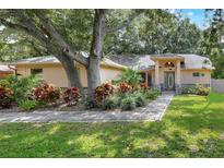 Charming single-story home featuring a beautiful walkway, lush landscaping, and a welcoming front entrance at 1300 Ariana Woods Cir, Auburndale, FL 33823