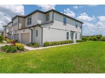 Beautiful two-story townhouse with manicured lawn and neutral tones offers a welcoming curb appeal at 1754 Sanibel Dr, Davenport, FL 33896