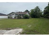 Charming single-story home with a well-maintained lawn and mature trees under a partly cloudy sky at 1820 Salem Rd, Lakeland, FL 33803