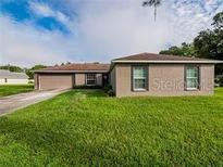 Single-story home with a well-maintained lawn and a two-car garage at 1824 Baltic Pl, Lakeland, FL 33809
