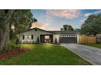 Charming single-story home featuring a well-manicured lawn, two-car garage, and stylish architectural details at 1920 Kimball S Ct, Lakeland, FL 33813