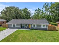 Charming single-story home with a well-manicured lawn and a welcoming yellow front door at 3016 Reiter Dr, Auburndale, FL 33823