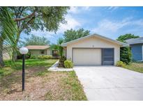 Charming single-story home with a two-car garage, lush landscaping, and inviting curb appeal at 5 Pine Run, Haines City, FL 33844
