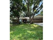 Charming single-story home with a well-maintained lawn and mature trees at 6342 Butternut Dr, Lakeland, FL 33813