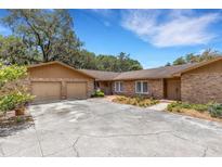 Charming single-story brick home with a two-car garage and lovely landscaped front yard at 6819 Broken Arrow S Trl, Lakeland, FL 33813