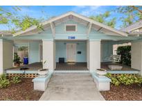 Charming bungalow with a welcoming front porch, swing, and beautiful landscaping at 817 College Ave, Lakeland, FL 33801