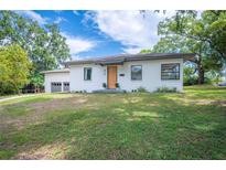 Charming single story home with a manicured lawn and attached two car garage at 818 Woodward St, Lakeland, FL 33803