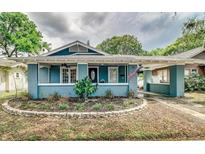 Charming home featuring a covered porch, manicured landscaping, and a driveway at 838 S Tennessee Ave, Lakeland, FL 33801