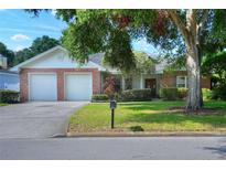 Charming single-story home featuring a brick facade, well-maintained lawn and mature landscaping at 1145 Denton St, Lakeland, FL 33803
