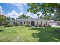 Charming single-story home featuring an arch window design, manicured lawn and landscaping at 1307 Fairlee St, Lakeland, FL 33813