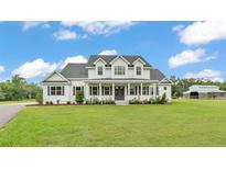 Beautiful two-story home with a classic white exterior, large front porch, and well-manicured lawn at 1385 Ewell Rd, Lakeland, FL 33811