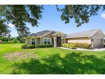 Charming single-story home featuring a well-manicured lawn and lush landscaping, offering great curb appeal at 1531 Blue Sky Blvd, Haines City, FL 33844