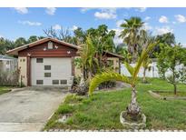 Charming home featuring a one-car garage and lush tropical landscaping at 1927 E Main St, Lakeland, FL 33801