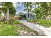 Charming home with lush landscaping, a carport, and a cozy screened-in porch offering great curb appeal at 2711 Crutchfield Rd, Lakeland, FL 33805