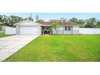 Charming single-story home with a well-manicured lawn and an attached two-car garage at 3080 Cross Fox Dr, Mulberry, FL 33860