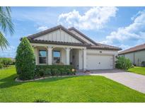 Charming single-story home featuring a well-manicured lawn and a stylish facade with a two car garage and tiled roof at 4124 Prima Lago Cir, Lakeland, FL 33810