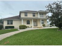 Inviting two-story home with a charming front porch, white railings, and well-maintained landscaping at 5480 Summerland Hills Dr, Lakeland, FL 33812