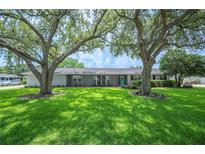 Charming single-story home with lush green lawn and mature trees providing shade at 5619 Stratford Ln, Lakeland, FL 33813