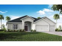 Charming single-story home featuring a well-manicured lawn, an arched entryway, and an attached two-car garage at 563 Silver Course Radl, Ocala, FL 34472