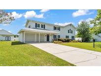 Charming two-story home with attached two-car garage and well-maintained lawn at 619 Somerset Loop, Auburndale, FL 33823