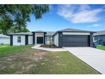 Charming single-story home featuring a well-manicured lawn, a two car garage, and attractive landscaping at 7642 Habersham Dr, Lakeland, FL 33810
