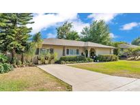 Charming one-story home featuring a well-maintained lawn, mature landscaping, and a long driveway at 841 E Valencia St, Lakeland, FL 33805