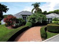 Landscaped front yard featuring mature trees, manicured hedges and a circular driveway leading to the home at 943 Hamilton Place Ln, Lakeland, FL 33813