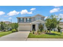 Charming two-story home with well-manicured lawn and gray wood facade at 1125 Mattie Pointe Blvd, Auburndale, FL 33823