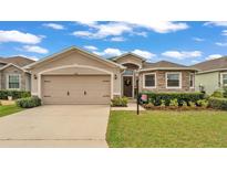 Charming single-Gathering home features a stone facade, well-maintained landscaping, and a two-car garage at 1129 Bowline St, Winter Haven, FL 33880
