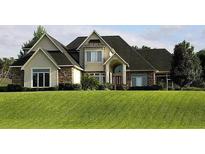 Attractive two-story home featuring stone accents and manicured lawn at 12740 Amber Ave, Clermont, FL 34711