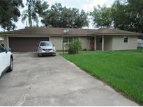 Charming single-story home with a well-maintained lawn, driveway, and attached garage at 1440 Hackl Blvd, Bartow, FL 33830