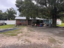 Single story home with a large tree in the front yard and a trailer nearby at 2293 Pump Rd, Mulberry, FL 33860