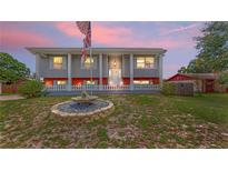 Charming two-story home featuring eye-catching architecture, a lovely fountain, and a well-maintained lawn at twilight at 2333 Cheshire Pl, Lakeland, FL 33810