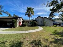 Charming single-Gathering home with a well-manicured lawn and mature landscaping at 241 Ash Ln, Lakeland, FL 33813