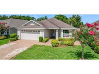 Charming single-story home featuring manicured landscaping and a brick driveway at 3806 Osprey Pointe Cir, Winter Haven, FL 33884