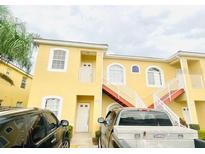 Inviting yellow condo featuring convenient stair access and well-maintained landscaping at 4102 Lake Marion Golf Resort # 4102, Kissimmee, FL 34759
