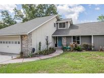 Charming home with a colorful front door, brick accents, and a well-manicured front yard at 929 Hammock Shade Dr, Lakeland, FL 33809