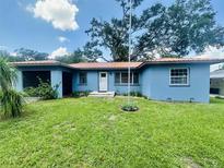 Charming single-story home featuring a metal roof and an expansive well-manicured front yard at 938 E Lowell St, Lakeland, FL 33805