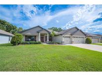 Beautiful front yard with lush green grass and a well-maintained exterior, featuring a three-car garage at 967 Hunters Meadow Ln, Lakeland, FL 33809