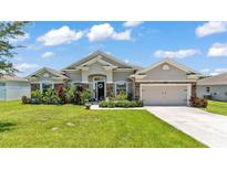 Charming single-story home features lush landscaping, a two-car garage, and attractive stone accents at 1028 15Th Ne St, Winter Haven, FL 33881