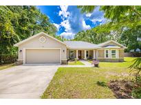 Charming single-story home with a well-manicured lawn, attached garage and a welcoming entrance at 13 Count Fleet Dr, Ocala, FL 34482