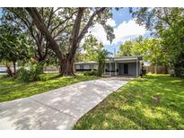 Charming single-story home with a long driveway and lush green lawn at 1604 Park Dr, Lakeland, FL 33803